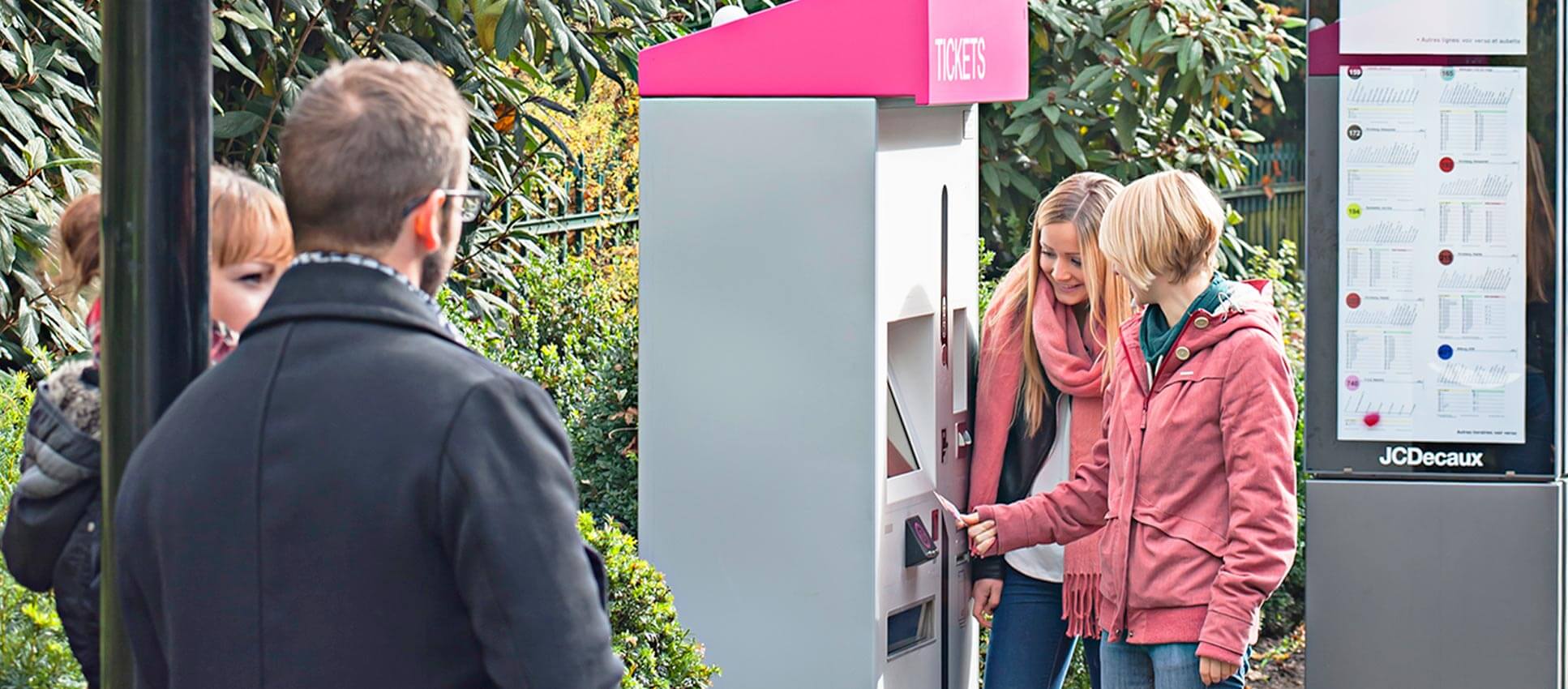 Young woman purchasing tickets at a ticket vending machine