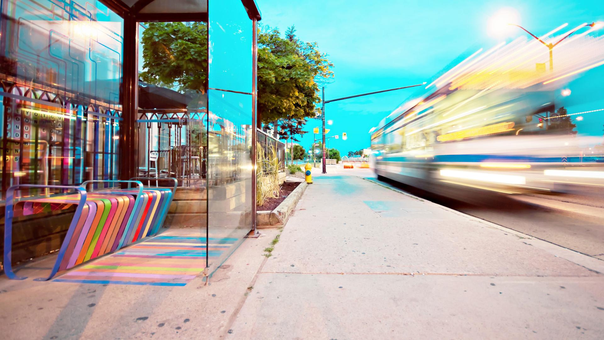 Brightly colored bus stop with moving bus