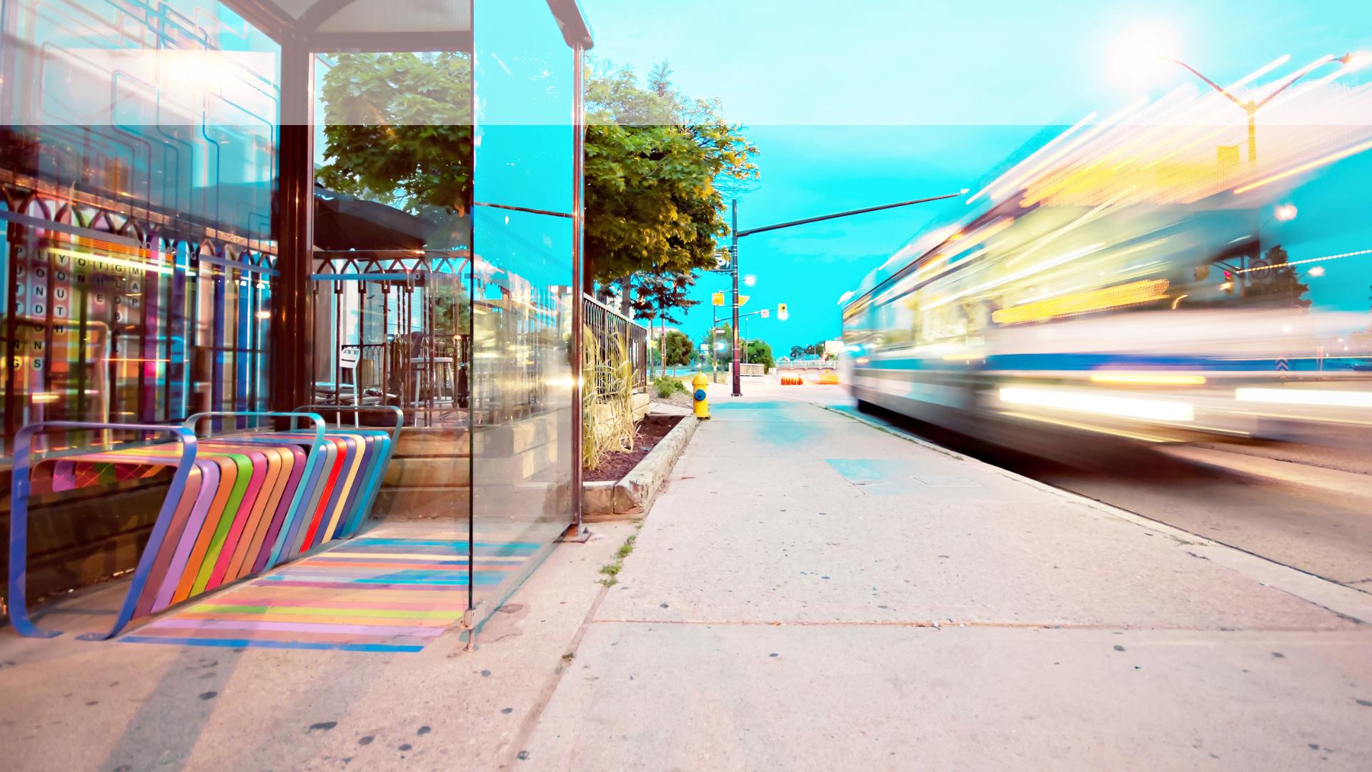 Brightly colored bus stop with moving bus